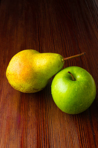 istock green apple and pear on wood table 929020050