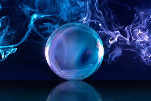 crystal ball and bluish smoke in dark background
