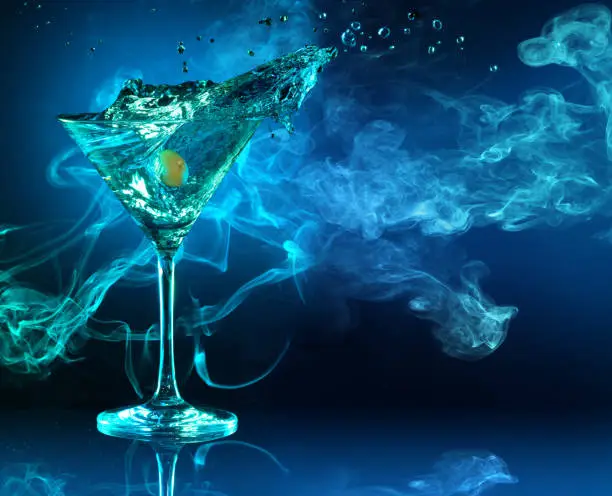 Photo of splashing martini and smoke in the background