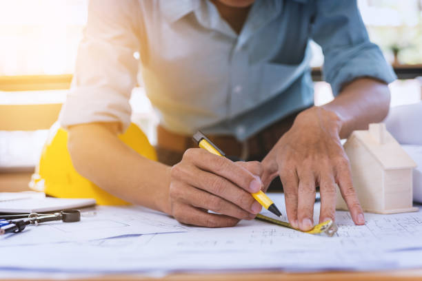 istock Close up of concentrated male engineer drawing hands working on architectural project at construction site at desk in office. 929024446