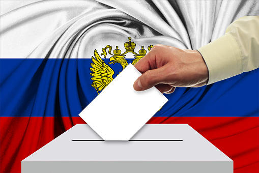 Man voting on elections in Russia front of flag