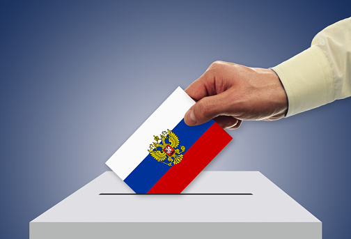 Male inserting flag into ballot box - Russia