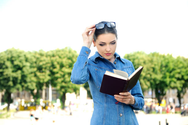 istock Girl in the park reading a book . 929032548
