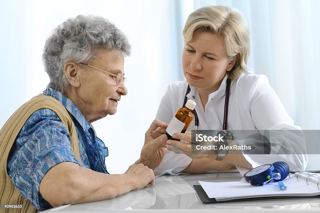 Doctor explaining prescription medicine to senior female A doctor explaining a pill dosage to a senior patient. Adult Stock Photo