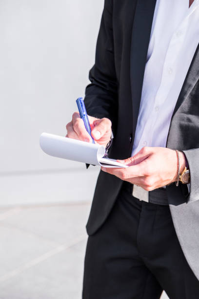 istock Male businessman or worker in black suit writing in notebook. 929037134
