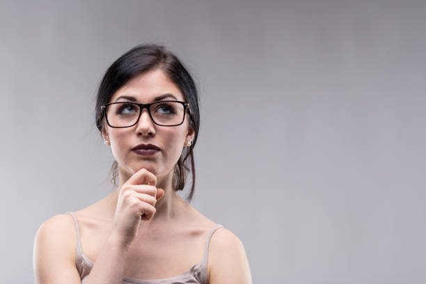 istock Attractive woman in glasses deep in thought 929037744