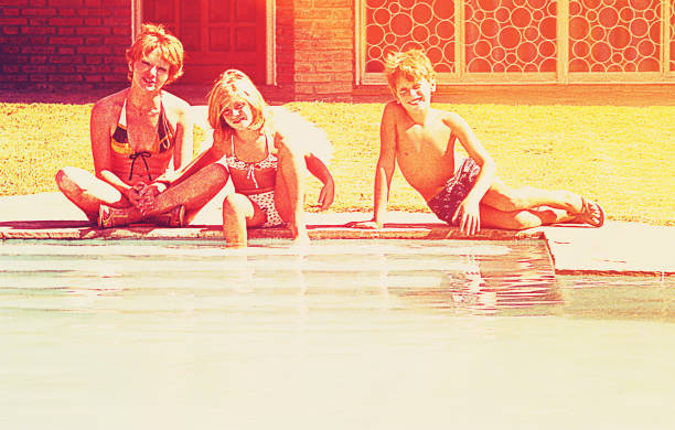 Vintage image of a mother and her children beside the swimming pool on summer vacation.
