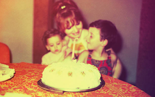 Vintage first birthday celebration Vintage image of a mother and her children in thedaughter first birthday day. 70s birthday party cake stock pictures, royalty-free photos & images