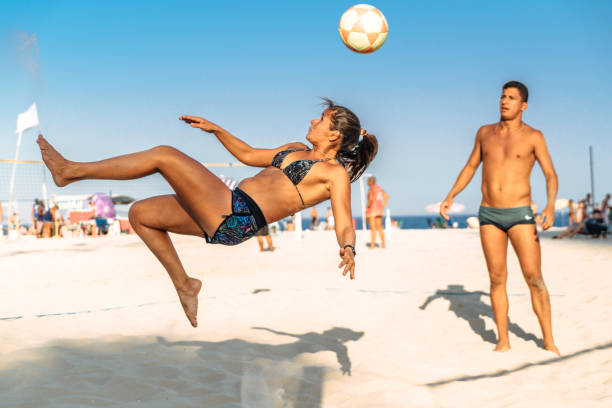 brazylijska kobieta skacze i kopie piłkę na plaży w brazylii - brazil beach copacabana beach recreational pursuit zdjęcia i obrazy z banku zdjęć