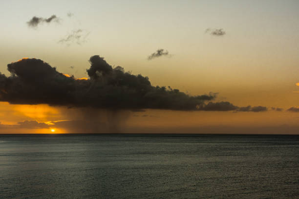 Dark rain cloud and rain at sunrise over the Atlantic Ocean