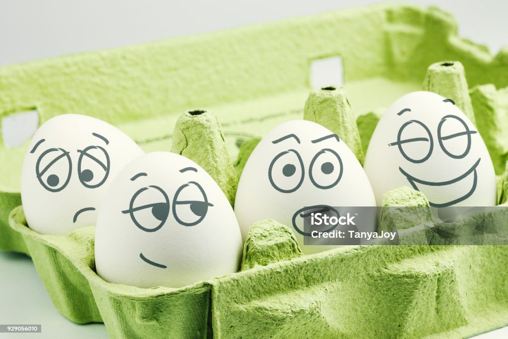 Four eggs in eggbox. Types of temperaments. Sanguine, choleric, phlegmatic and melancholic. Individuality Stock Photo