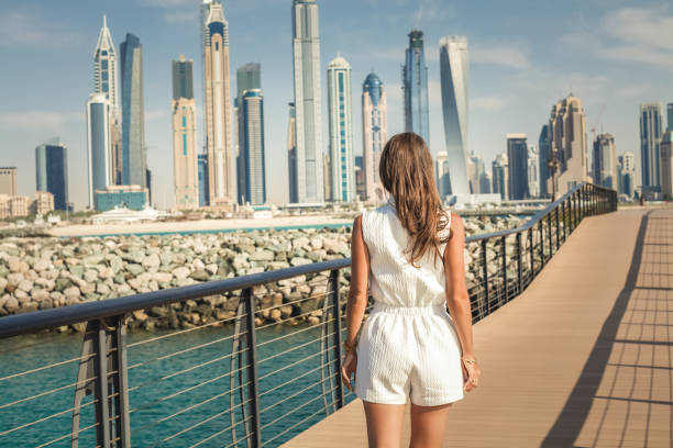 Lady runs over the bridge, enjoying view of Dubai city. stock photo