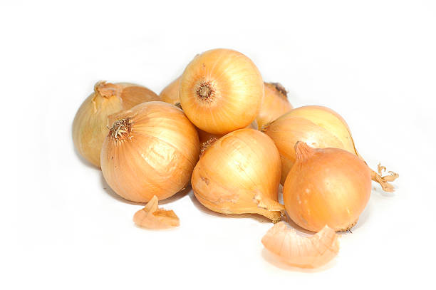 Pile of brown onions on white background