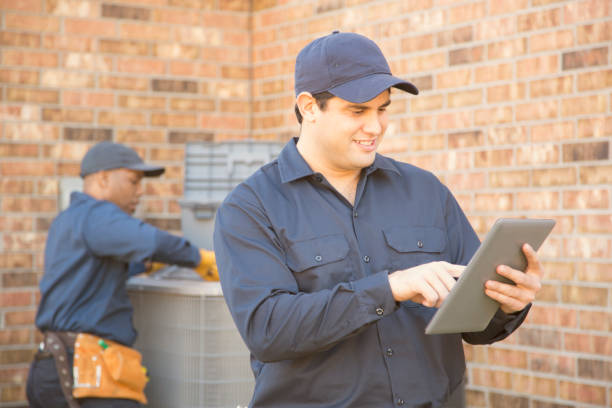 istock Multi-ethnic team of blue collar air conditioner repairmen at work. 929068220