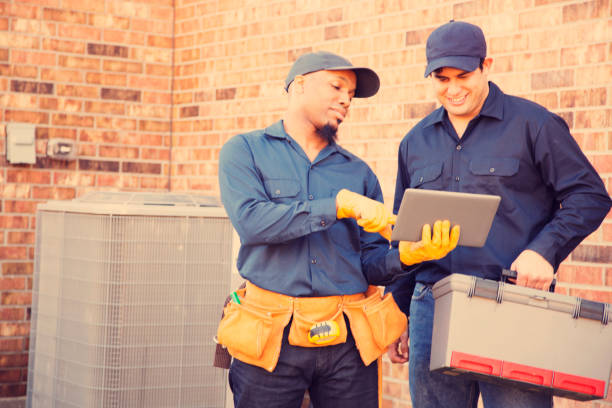 istock Multi-ethnic team of blue collar air conditioner repairmen at work. 929070616