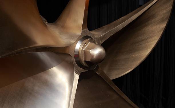 A closeup of a large boat propeller brand new Large polished brass boat propeller with 6 blades. Depth of field with focal point on very center. propeller stock pictures, royalty-free photos & images