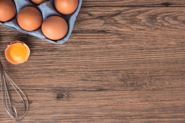 istock Cardboard egg box on wooden table. Top view with copy space 929087864
