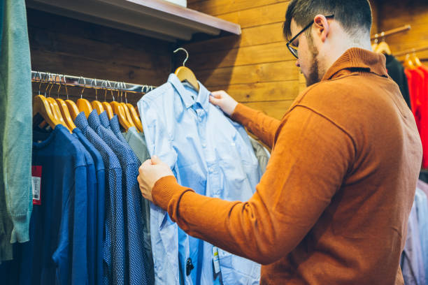 homem fazer compras na loja. escolha camisas na loja - shirt button down shirt hanger clothing - fotografias e filmes do acervo