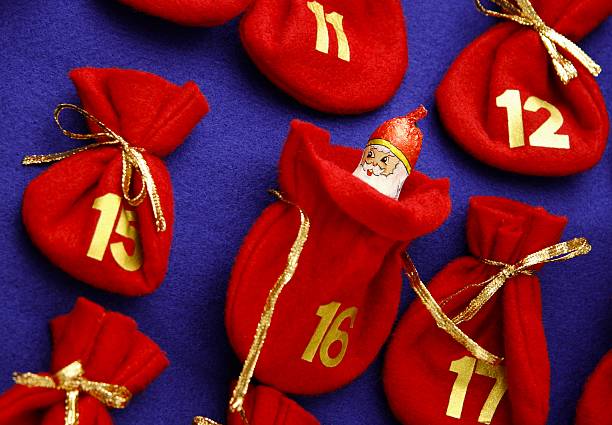 Woman making Christmas advent calendar. Pouches on a rope.