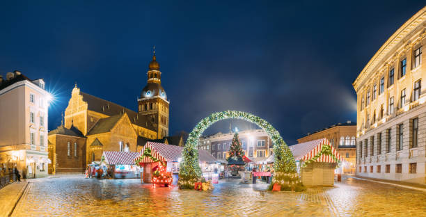 istock Riga, Latvia. Xmas Market On Dome Square With Riga Dome Cathedral. Christmas Tree And Trading Houses. Famous Landmark At Winter Evening Night In Illuminations Light 929102706