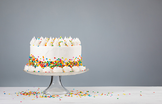 Pastel birthday cake with three birthday candles and sparkler