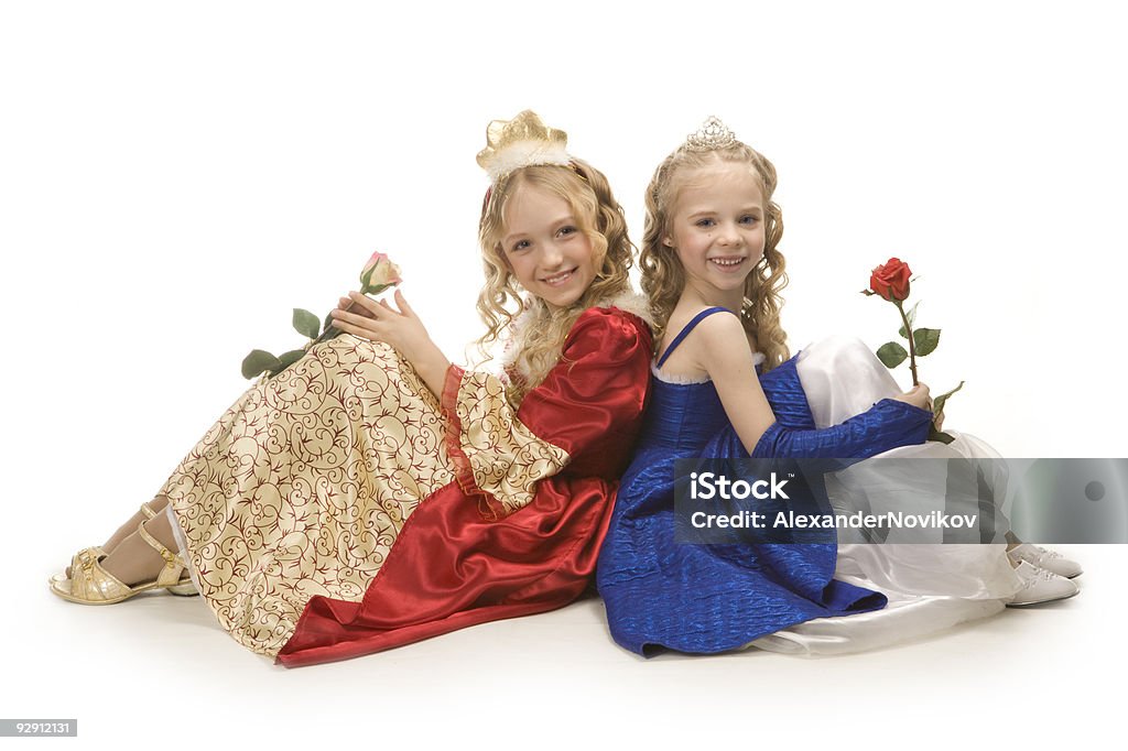 Two beautiful happy little  princesses sitting on floor with  roses.  Beautiful People Stock Photo