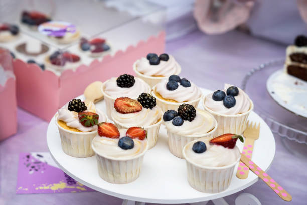 istock Different appetizing tartlets, cake basket with white cream and fresh multi-colored berries, Fresh summer dessert, selective focus with blueberries, blackberries, strawberries 929123450