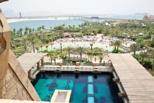 woman enjoying Dubai marina skyline from luxury hotel infinity pool. banner with copy space