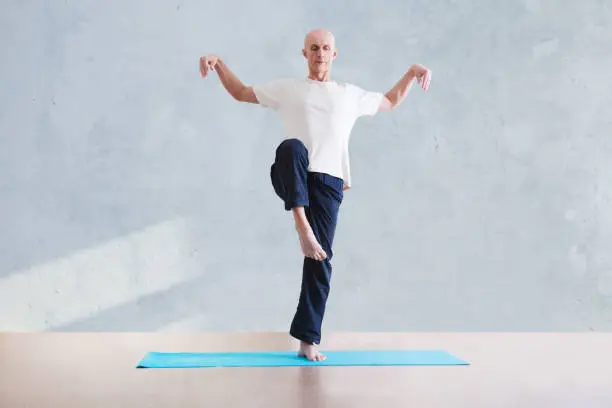 Photo of man praticing tai chi chuan in the gym. Chinese management skill Qi's energy. WU-SHU. Man practice yoga