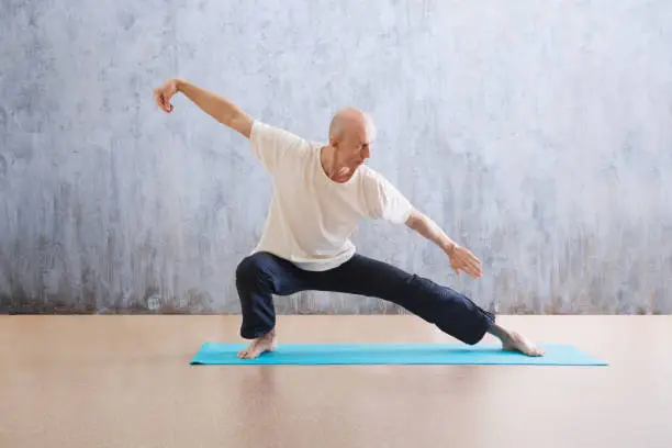 Photo of man praticing tai chi chuan in the gym. Chinese management skill Qi's energy. WU-SHU. Man practice yoga