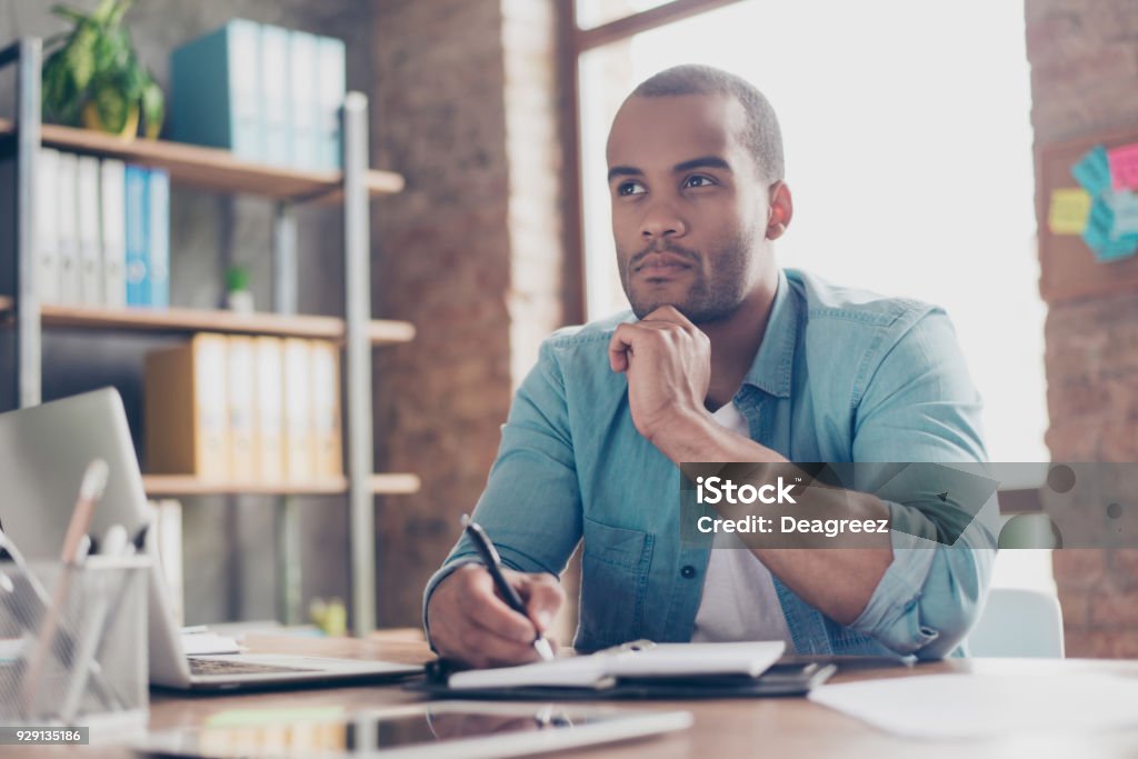 Cético, conceito de inseguro, incerto, dúvidas. Jovem estudante Africano é tomar decisão sentado no escritório em smart casual - Foto de stock de Contemplação royalty-free