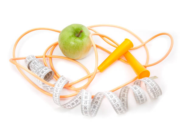 A green apple, tape measure and rope stock photo