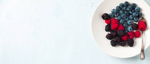 istock Fruit salad with Various fresh summer berries in white plate . Top view 929140538