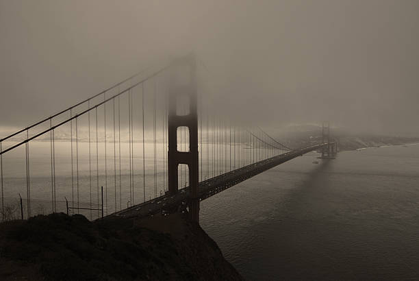 foggy golden gate bridge und grau stormclouds - golden gate bridge bridge weather california stock-fotos und bilder