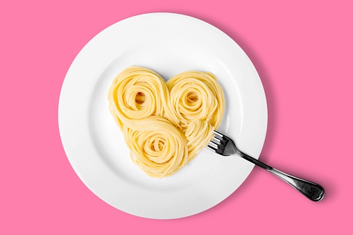 Spaghettin in heart shape on white plate