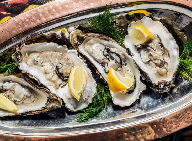 istock Opened oysters with piece of lemon. 929154606