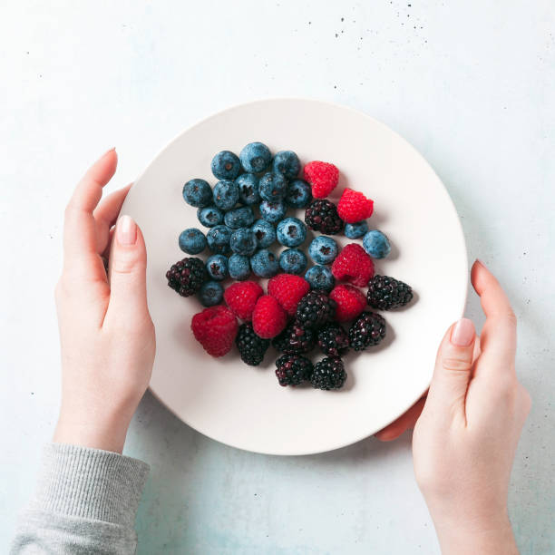 istock Fruit salad with Various fresh summer berries in white plate . Top view 929168142