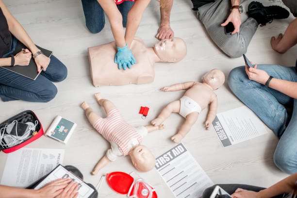First aid training Group of people learning how to make first aid heart compressions with dummies during the training indoors cpr stock pictures, royalty-free photos & images