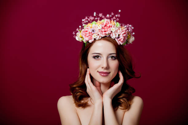 istock Young redhead girl with wreath on red background 929196822