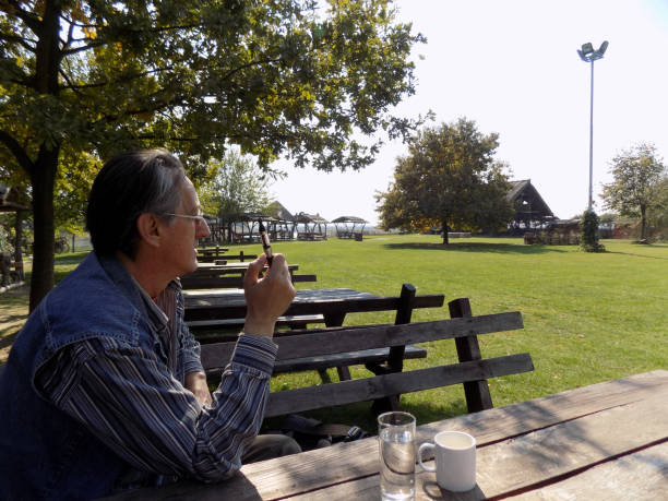 Man sitting under the tree, in the restaurant in the park
