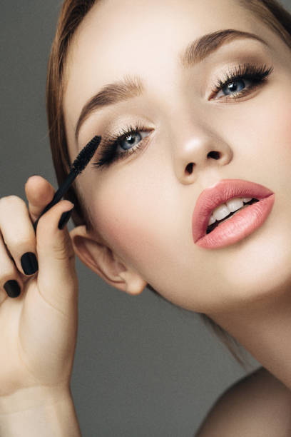 Beautiful woman applying mascara
