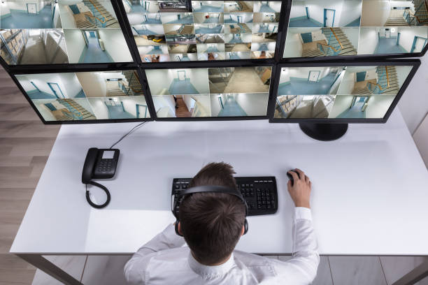 istock Security Guard Monitoring Multiple Camera Footage On Computer 929210750