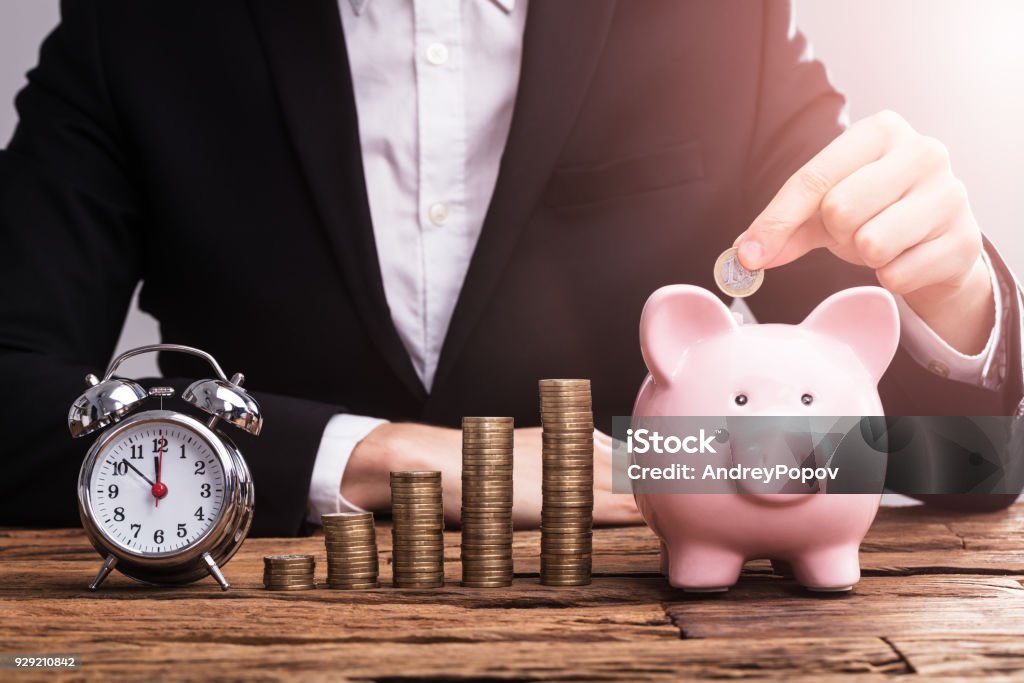 Mano de empresario poner moneda en Piggybank - Foto de stock de Ahorros libre de derechos