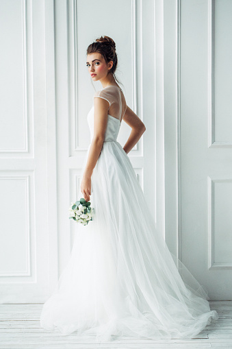 Beautiful brunette woman as bride with wedding bouquet