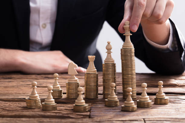 istock Businessperson Arranging Chess Piece On Stacked Coins 929211476