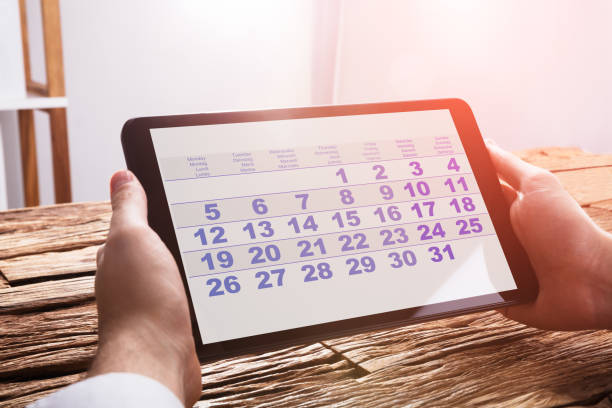 Close-up Of A Businessperson's Hand Using Calendar On Digital Tablet