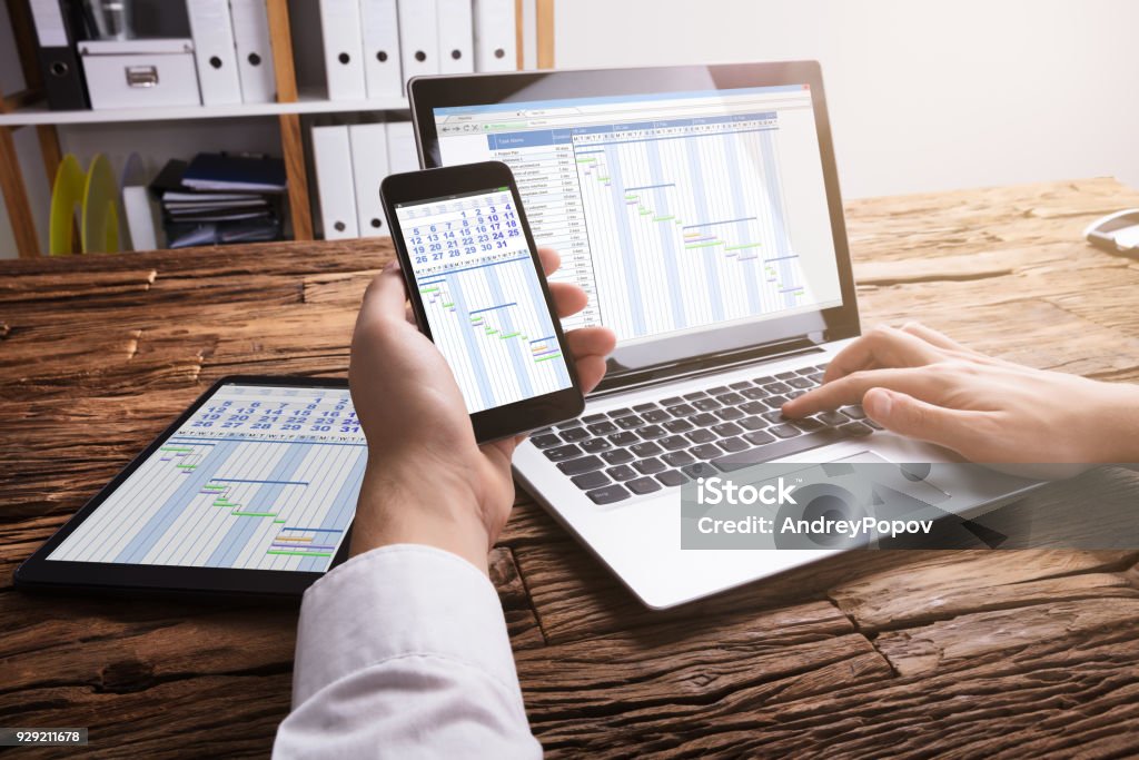 Homme d’affaires analysant le diagramme de Gantt sur ordinateur portable - Photo de Agenda libre de droits