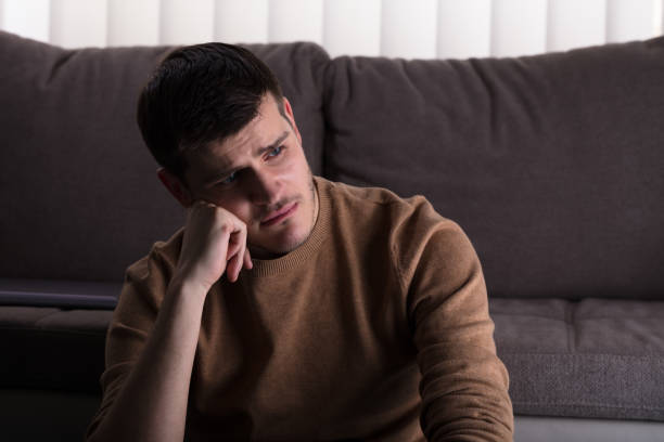 istock Sad Man Sitting In Front Of Sofa 929212216
