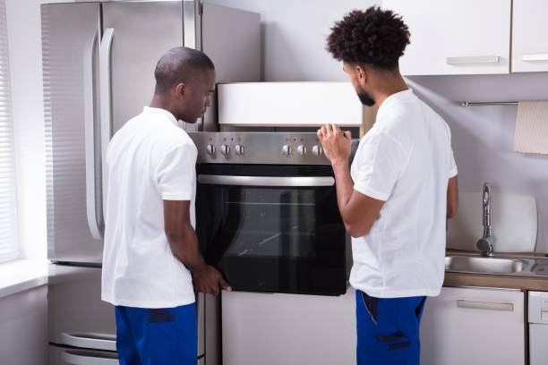 istock Two Male Workers Placing The Oven In The Kitchen 929212644