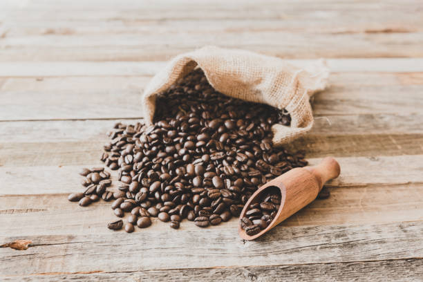 istock Roasted coffee beans in a bag on wooden background 929215406